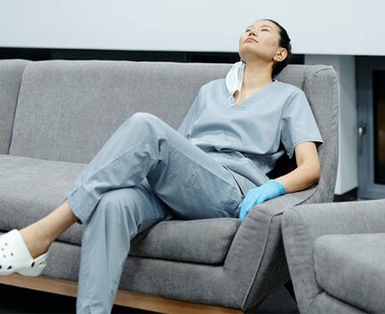 Covid-19 nurse sleeping on couch with gloves and mask on