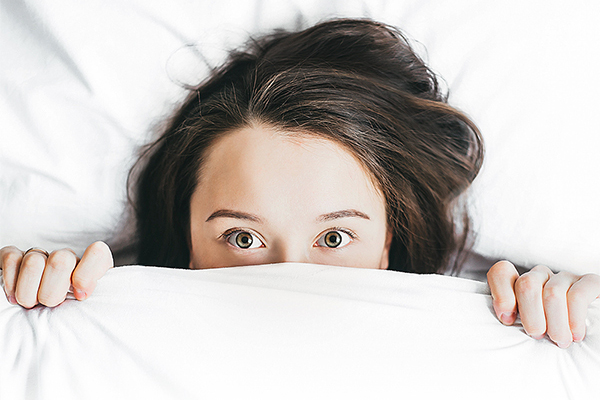 frustrated woman hiding in bed