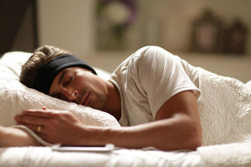 man sleeping with black SleepPhones headphones for tinnitus