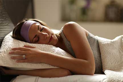 woman sleeping on side wearing lavender sleepphones