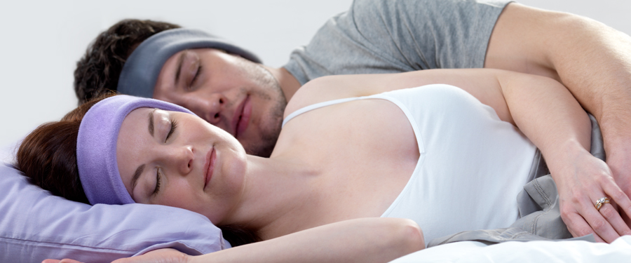 couple sleeping in bed with SleepPhones on